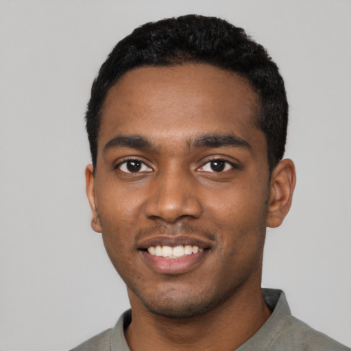 Joyful black young-adult male with short  black hair and brown eyes