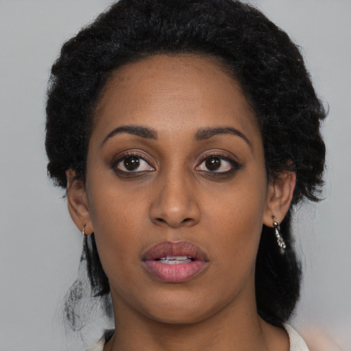 Joyful black young-adult female with medium  black hair and brown eyes
