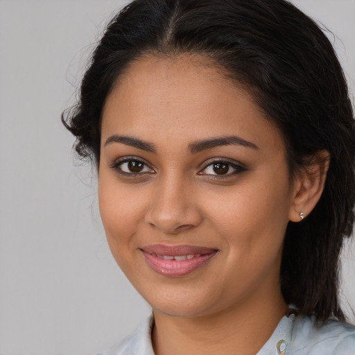 Joyful latino young-adult female with medium  brown hair and brown eyes