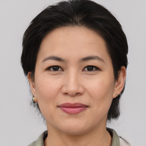 Joyful asian adult female with medium  brown hair and brown eyes