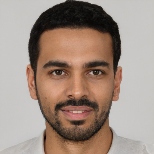 Joyful latino young-adult male with short  black hair and brown eyes