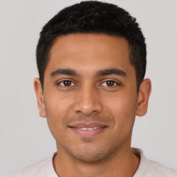 Joyful latino young-adult male with short  black hair and brown eyes