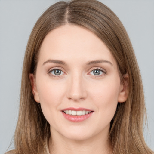 Joyful white young-adult female with long  brown hair and grey eyes