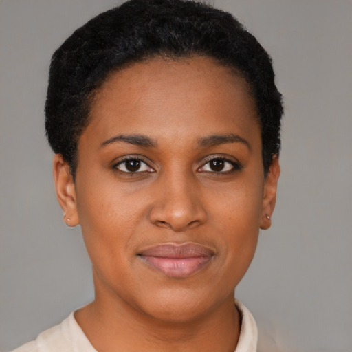 Joyful black young-adult female with short  black hair and brown eyes