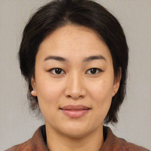 Joyful asian adult female with medium  brown hair and brown eyes