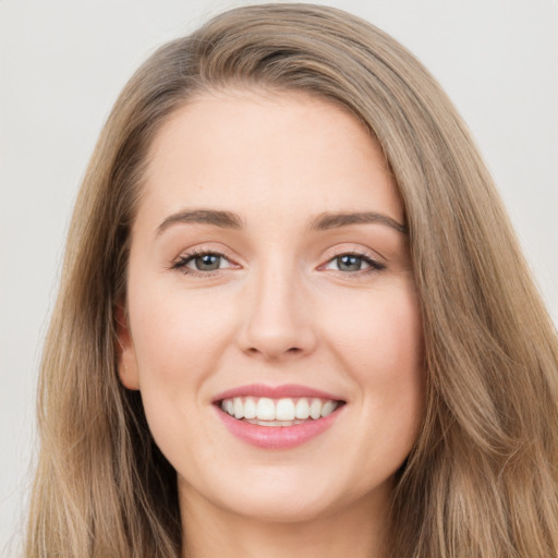 Joyful white young-adult female with long  brown hair and green eyes