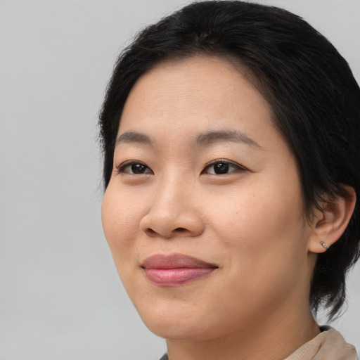 Joyful asian young-adult female with medium  brown hair and brown eyes