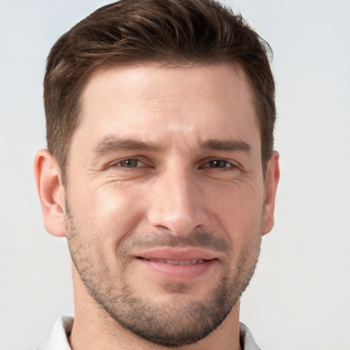 Joyful white young-adult male with short  brown hair and grey eyes