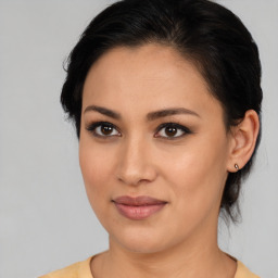 Joyful latino young-adult female with medium  brown hair and brown eyes