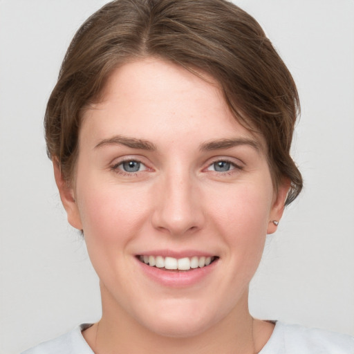 Joyful white young-adult female with short  brown hair and grey eyes