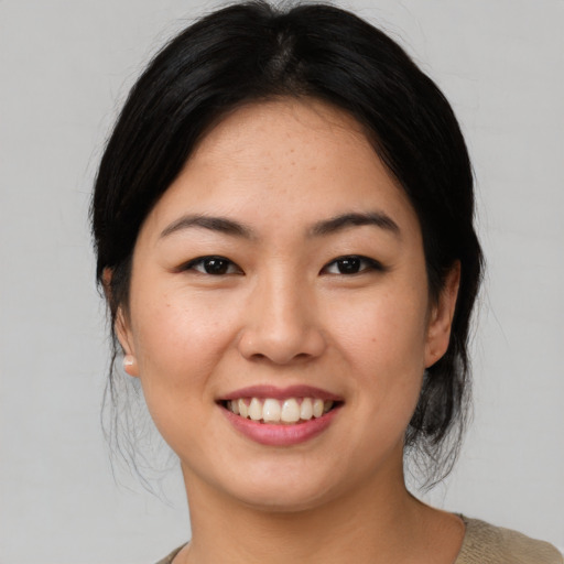 Joyful asian young-adult female with medium  black hair and brown eyes