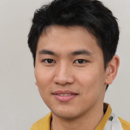 Joyful asian young-adult male with short  brown hair and brown eyes