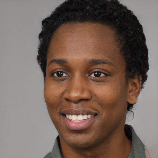 Joyful black young-adult female with short  black hair and brown eyes