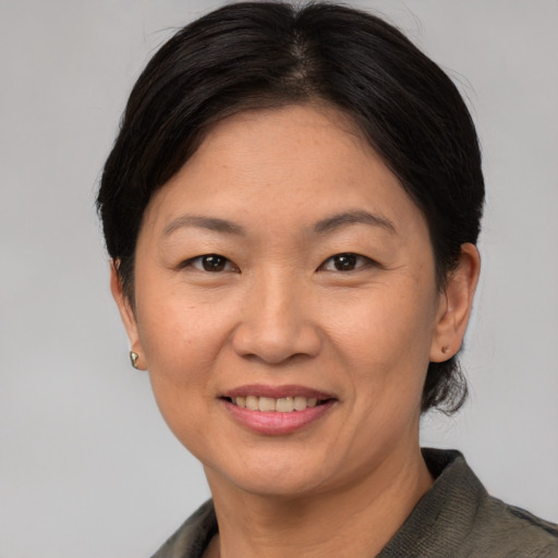 Joyful asian adult female with short  brown hair and brown eyes