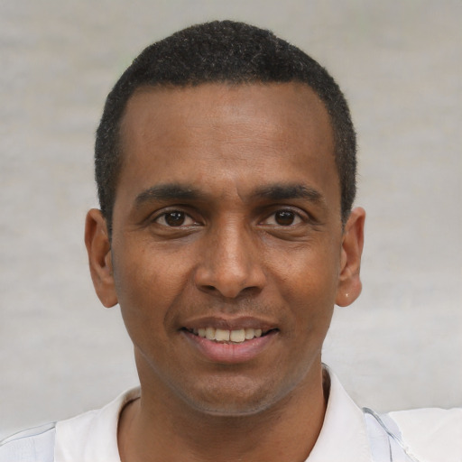 Joyful black young-adult male with short  brown hair and brown eyes