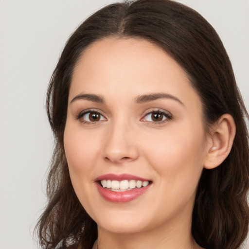 Joyful white young-adult female with long  brown hair and brown eyes