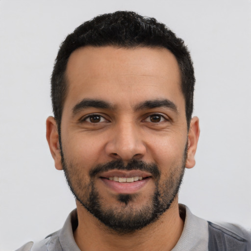 Joyful latino young-adult male with short  black hair and brown eyes