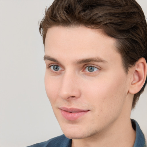 Joyful white young-adult male with short  brown hair and blue eyes