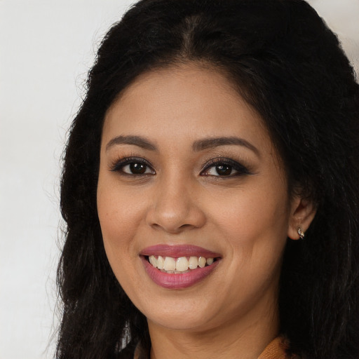 Joyful latino young-adult female with long  brown hair and brown eyes