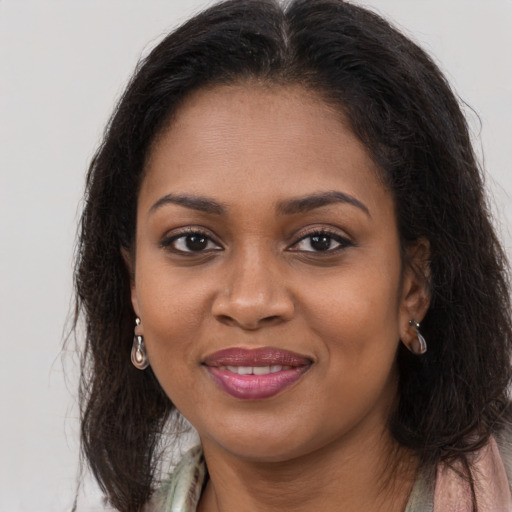 Joyful black young-adult female with long  brown hair and brown eyes