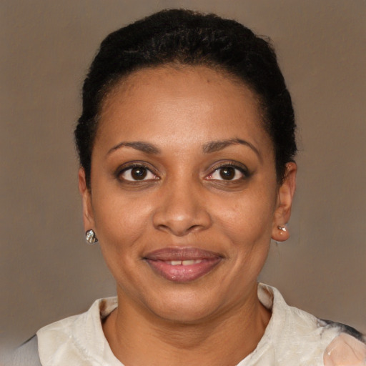 Joyful black young-adult female with short  black hair and brown eyes