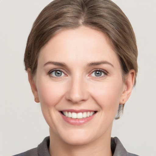 Joyful white young-adult female with medium  brown hair and grey eyes