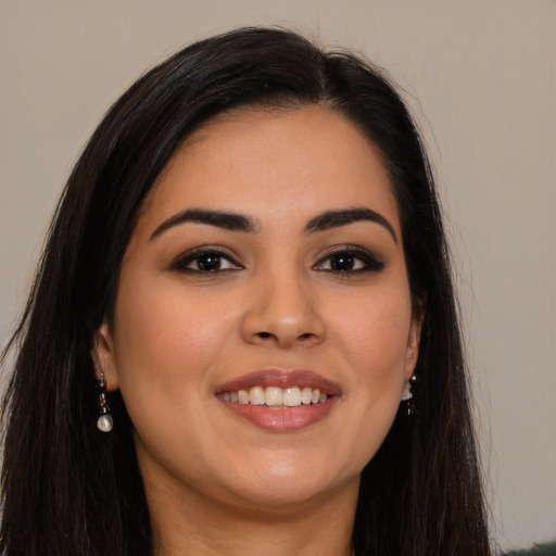 Joyful latino young-adult female with long  brown hair and brown eyes