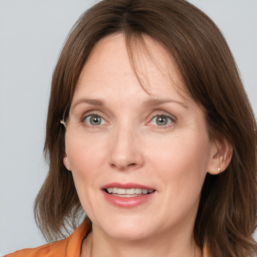 Joyful white adult female with medium  brown hair and grey eyes