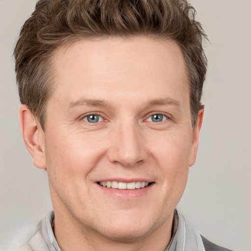 Joyful white adult male with short  brown hair and grey eyes