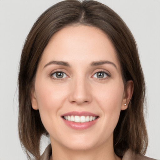 Joyful white young-adult female with long  brown hair and grey eyes