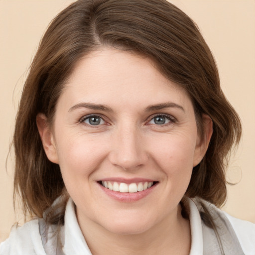 Joyful white young-adult female with medium  brown hair and grey eyes