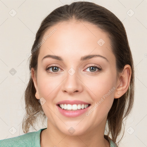 Joyful white young-adult female with medium  brown hair and grey eyes