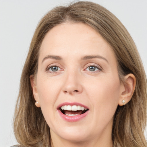 Joyful white young-adult female with long  brown hair and grey eyes