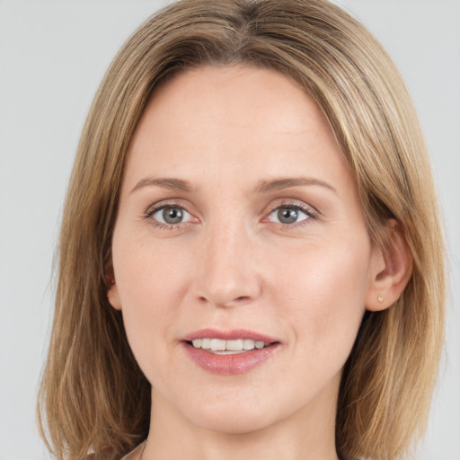 Joyful white young-adult female with medium  brown hair and green eyes