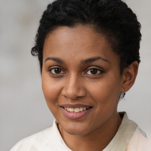 Joyful black young-adult female with short  brown hair and brown eyes