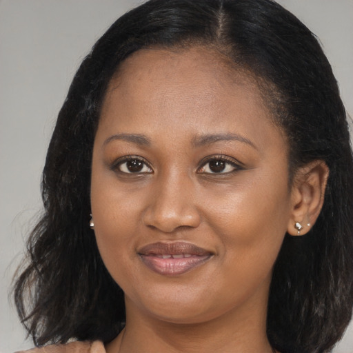 Joyful black young-adult female with long  brown hair and brown eyes