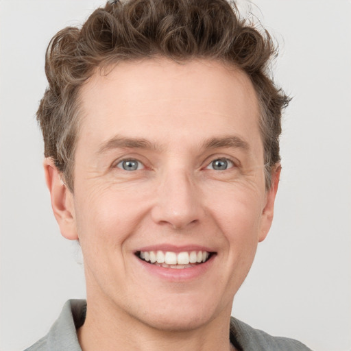 Joyful white adult male with short  brown hair and grey eyes