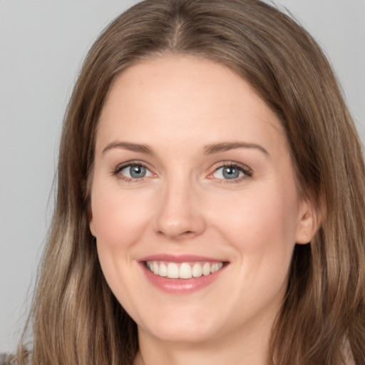 Joyful white young-adult female with long  brown hair and grey eyes