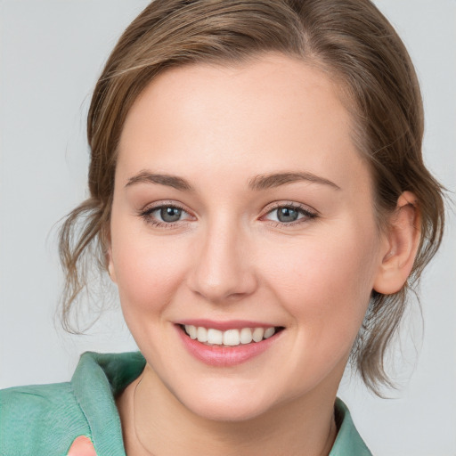 Joyful white young-adult female with medium  brown hair and blue eyes