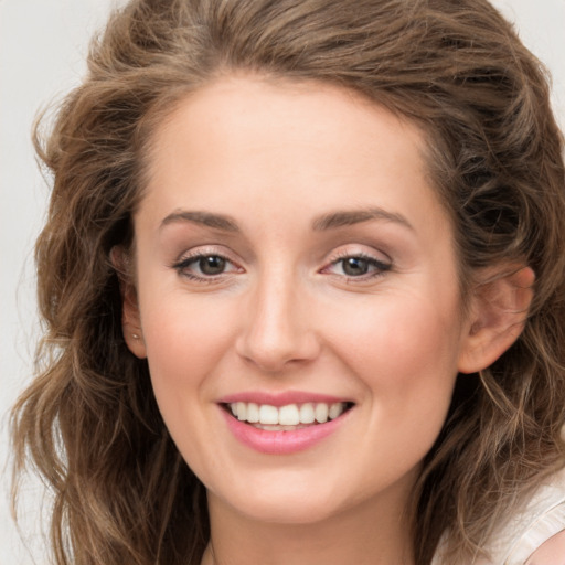 Joyful white young-adult female with medium  brown hair and green eyes