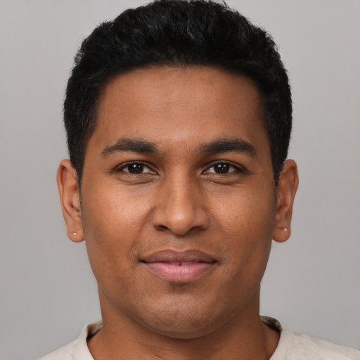 Joyful latino young-adult male with short  black hair and brown eyes