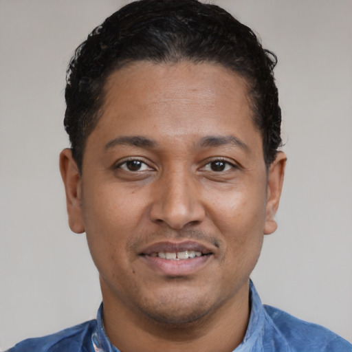 Joyful latino adult male with short  brown hair and brown eyes