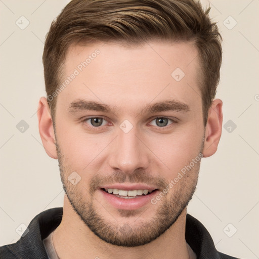 Joyful white young-adult male with short  brown hair and grey eyes