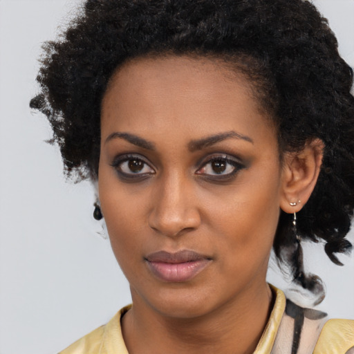 Joyful black young-adult female with long  black hair and brown eyes
