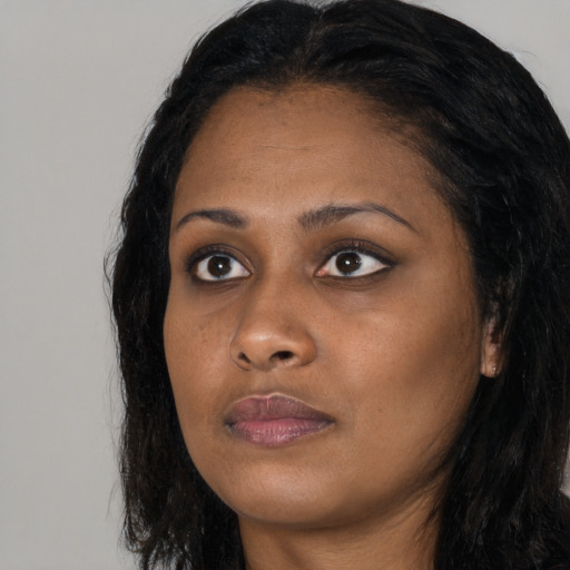 Joyful black young-adult female with long  black hair and brown eyes