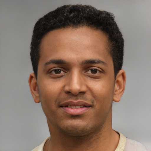Joyful black young-adult male with short  brown hair and brown eyes