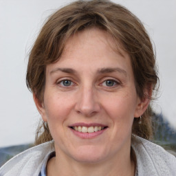 Joyful white adult female with medium  brown hair and grey eyes