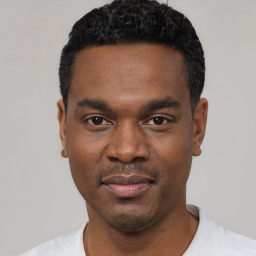 Joyful black young-adult male with short  black hair and brown eyes