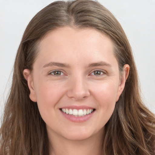 Joyful white young-adult female with long  brown hair and grey eyes