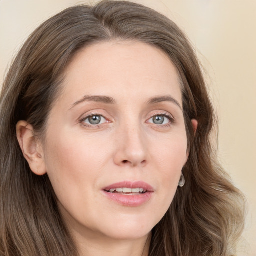 Joyful white young-adult female with long  brown hair and grey eyes